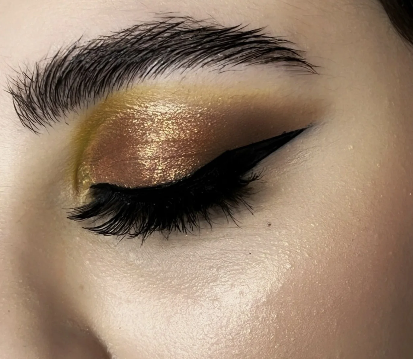 Dettaglio di ombretto oro con eyeliner nero definito
