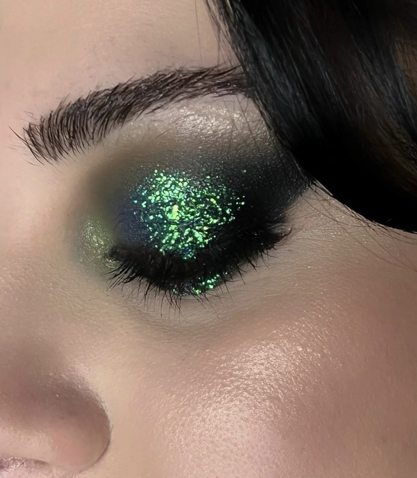 Dettaglio di trucco occhi verde scuro con glitter luminosi