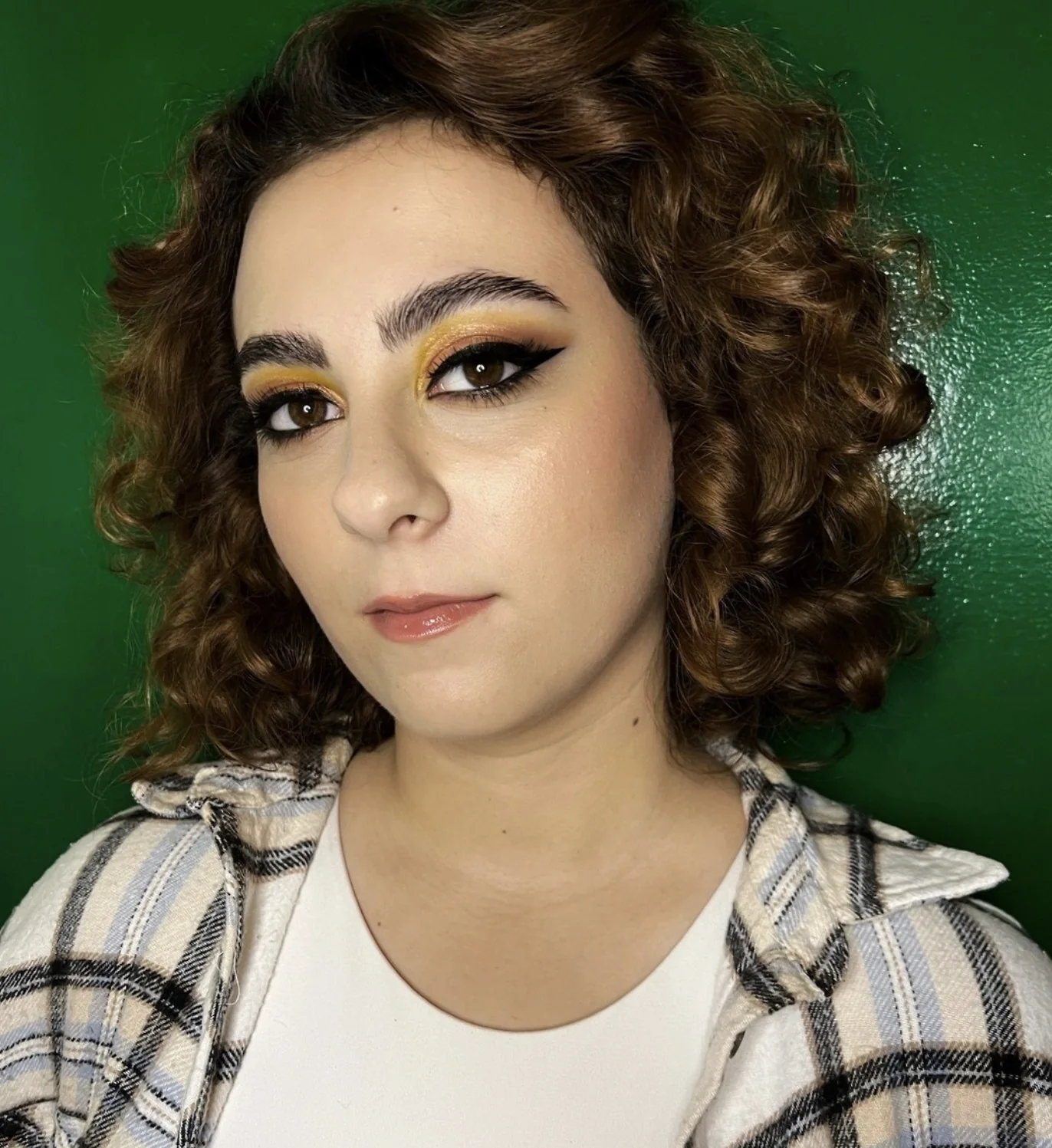 Ritratto beauty con ombretto oro e eyeliner su modella riccia