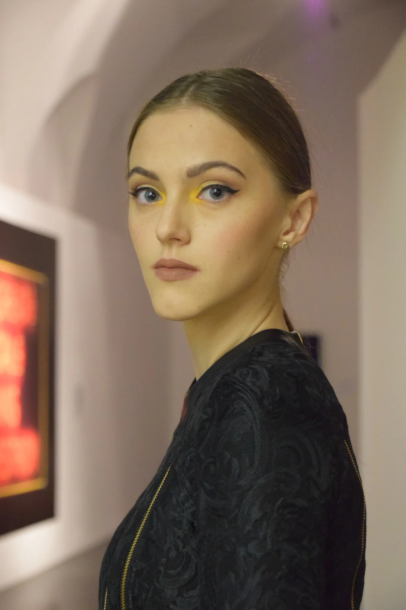 Trucco editoriale con eyeliner grafico e dettaglio giallo