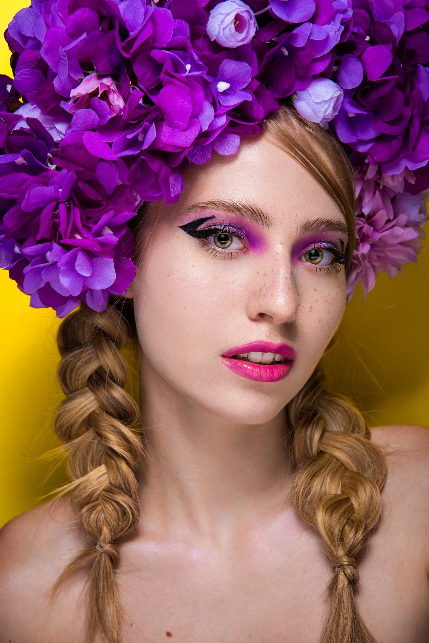 Primo piano con trucco editoriale viola e copricapo floreale