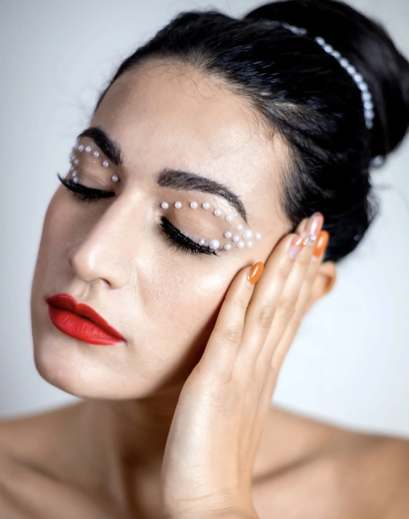 Trucco editoriale con perle sugli occhi e labbra rosse