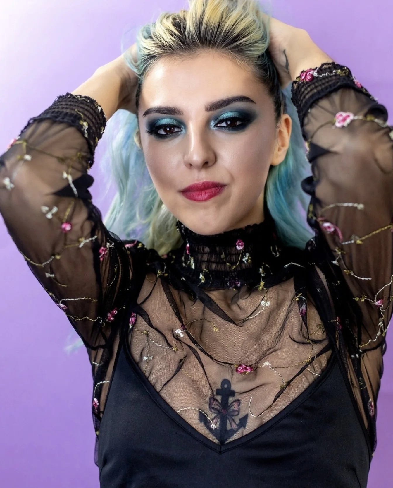 Ritratto frontale con make-up blu su sfondo viola